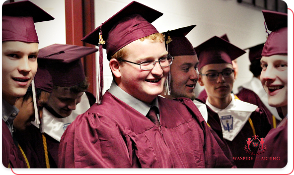 Group of smiling male students wearing maroon graduation caps and gowns